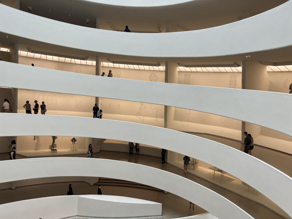 A photo showing several floors of the inside of the Guggenheim museum in NYC with Gego's work on display.